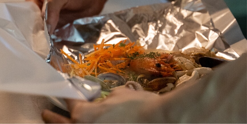 レストラン カルタパコの紙包みパスタを包む様子